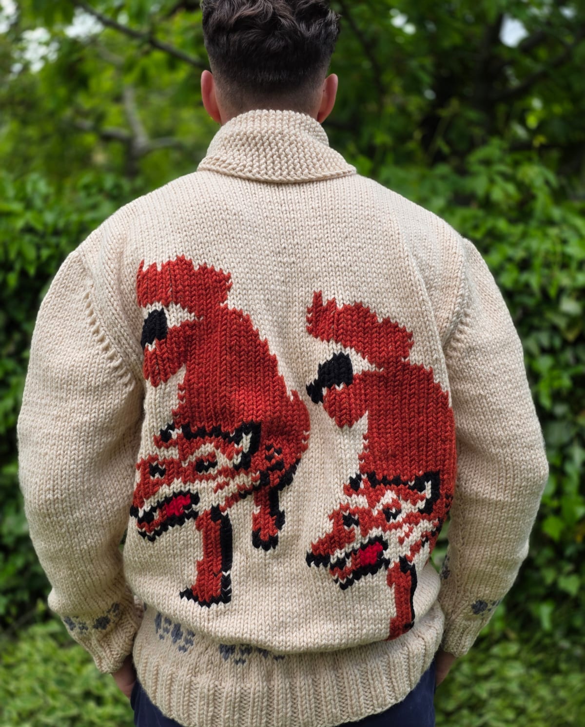 Fox cardigan — back view, two red foxes walking down, model in forest setting