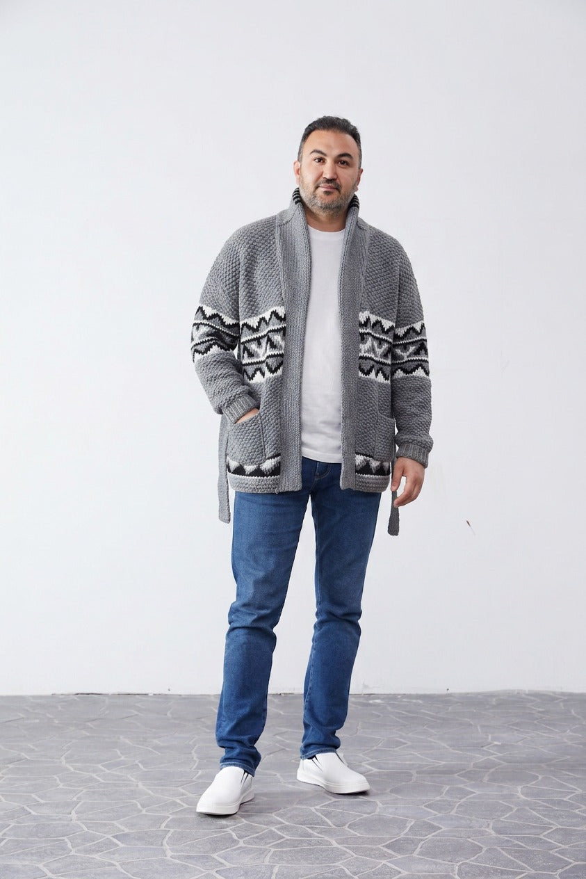 Man wearing the grey Starsky and Hutch hand-knit Cowichan-style cardigan with black and white pattern bands and tie belt