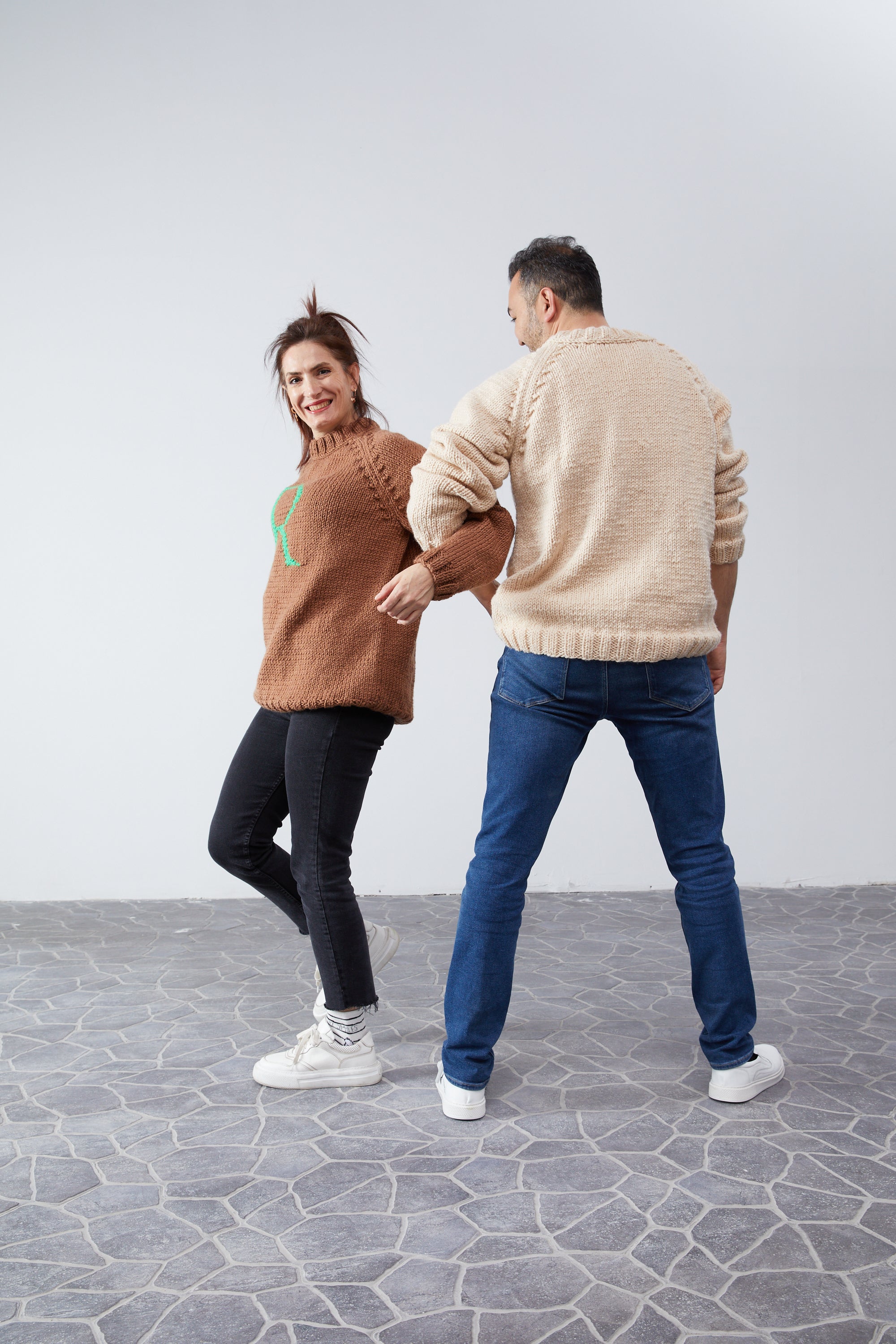 Couple in Monogram Weasley jumpers, playful back-view shot