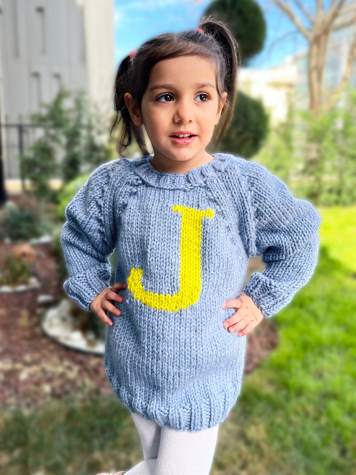 Girl in blue kids monogram sweater with yellow J letter — hand-knit